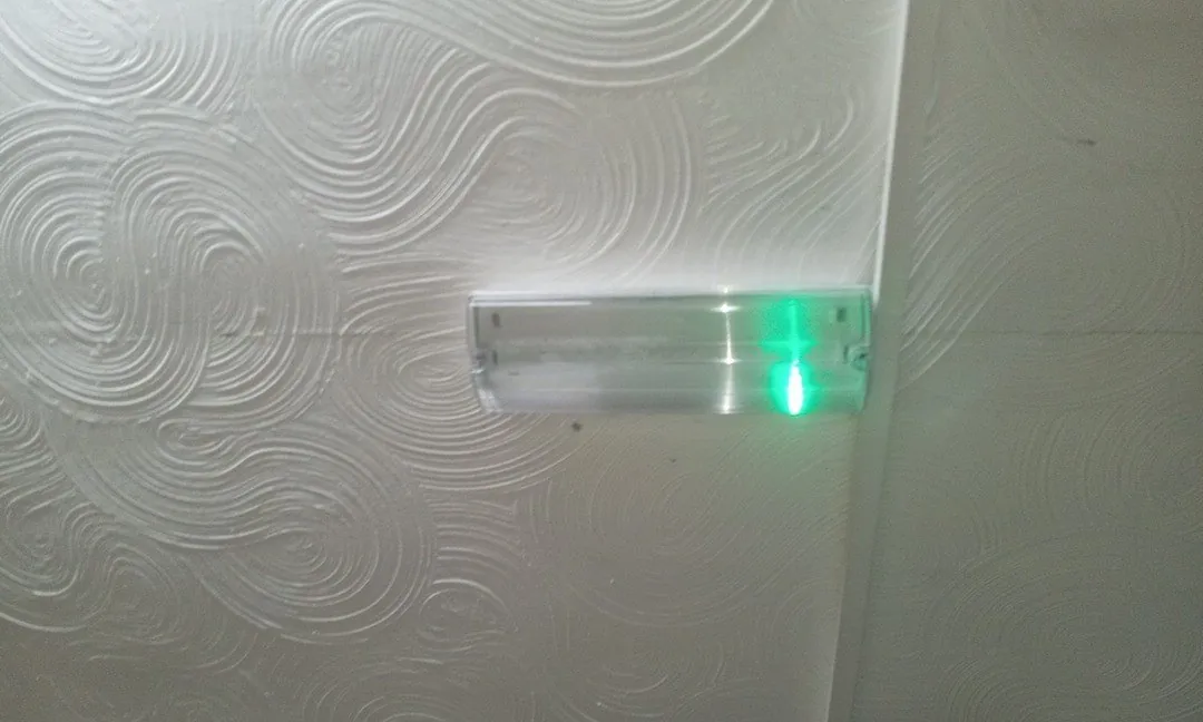 Emergency light fitting with its green charging light on