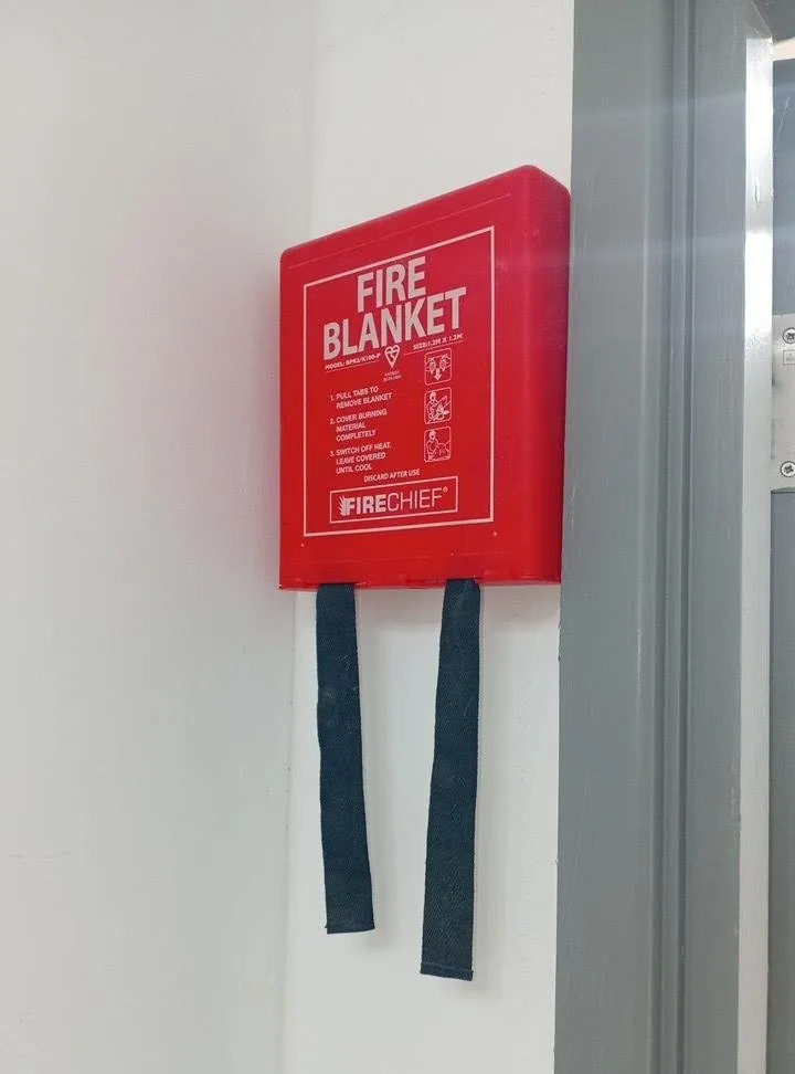 Fire blanket mounted on a wall by a doorway