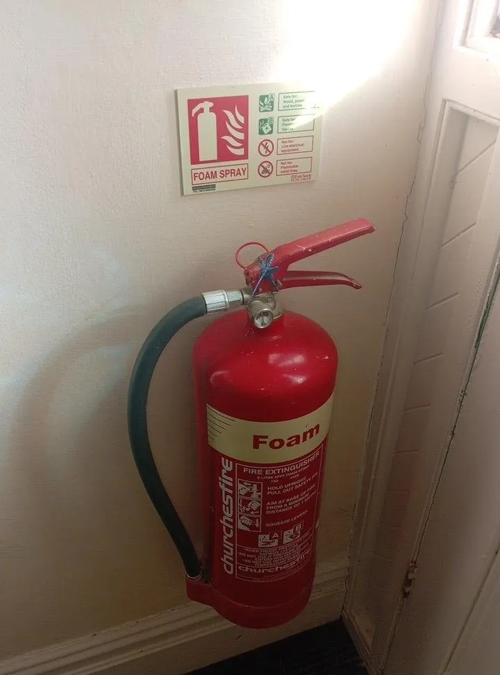 Wall-mounted foam fire extinguisher with its ID sign